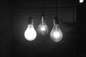 Three Hanging Light Bulbs in a Dark Room photo