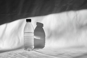 A Single Water Bottle with a Shadow Cast on a White Surface photo