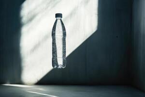 A Clear Water Bottle Floating in a Beam of Sunlight Against a Gray Wall photo