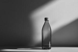 A Single Water Bottle Against a White Wall with Shadows photo