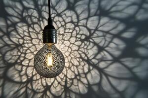 A decorative light bulb casting an intricate shadow on a wall photo