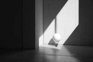 A Single White Lightbulb on a Gray Floor with Sunlight Streaming Through a Window photo