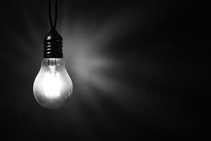 A Single Lightbulb Hanging in a Dark Room photo