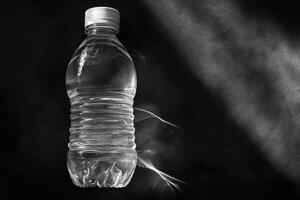 A Single Plastic Water Bottle on a Black Surface photo