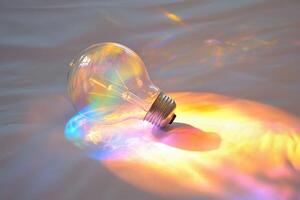 A Lightbulb Casting Rainbow Light on a White Fabric photo