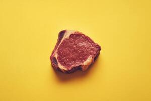Raw Beef Steak on Yellow Background photo