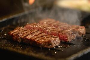 Grilled Steak Pieces Sizzling On A Hot Griddle photo