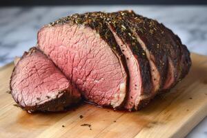 Sliced Herb Crusted Roast Beef On Wooden Board photo
