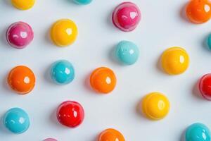 Colorful glossy spherical candies arranged on white background photo