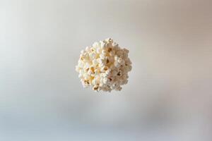 A spherical cluster of popcorn floats against a plain background photo