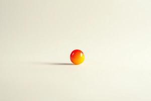 A single orange and yellow sphere rests on a white background photo
