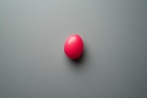 A Single Pink Egg on a Gray Background photo