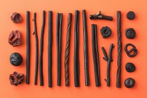 Assorted Licorice Candy Arranged On Orange Background photo