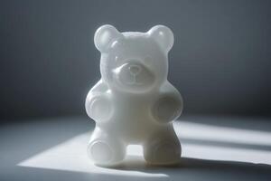 White textured teddy bear figurine sits on white surface photo