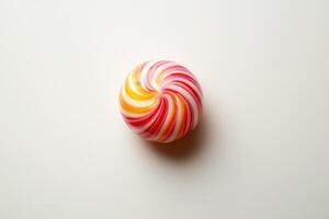 Swirled hard candy rests on white background photo