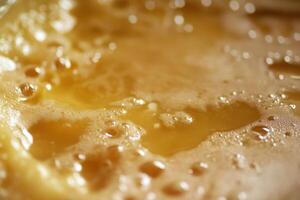 Golden Honey Surface Close Up Showing Bubbles photo