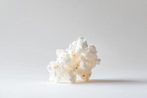 A cluster of fluffy white popcorn rests on a white background photo