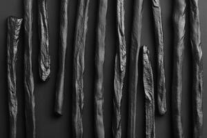 Black textured sticks arranged in a vertical pattern photo