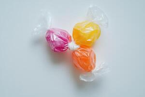 Three Colorful Candies Wrapped In Clear Plastic photo