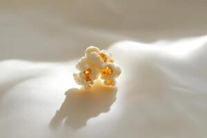 A Small Cluster Of Popcorn On A White Surface photo