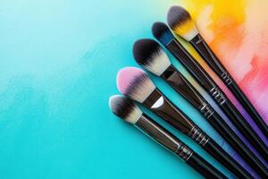 Colorful Makeup Brushes Arranged On A Teal Background photo