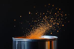 Orange powder explodes from metallic container photo