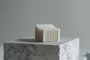 White soap bar rests on a marble block photo