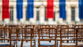 Rows of empty chairs facing a building with flags. photo