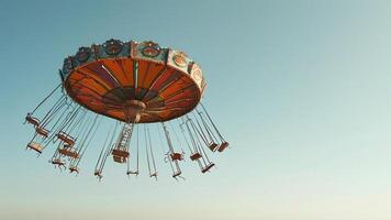 Chair swing ride against a clear blue sky photo