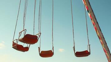 Empty chair swing ride against a clear blue sky. photo