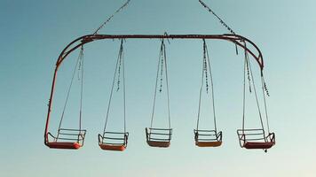 Empty swing set against a clear blue sky photo