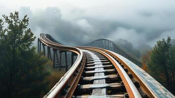 Rollercoaster track in foggy mountains photo