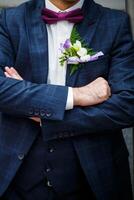 Man puts on a wedding suit and accessories on the wedding day. photo