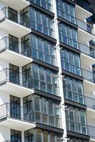 grande panorámico el plastico ventanas fachada de un nuevo edificio en el casa durante construcción trabajar. de muchos pisos edificio durante construcción foto