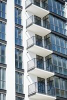 grande panorámico el plastico ventanas fachada de un nuevo edificio en el casa durante construcción trabajar. de muchos pisos edificio durante construcción foto