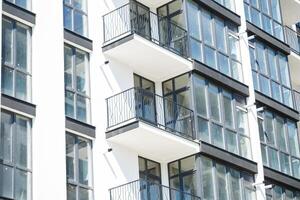 Large panoramic plastic windows. Facade of a new building in the house during construction work. Multi-storey building during construction photo