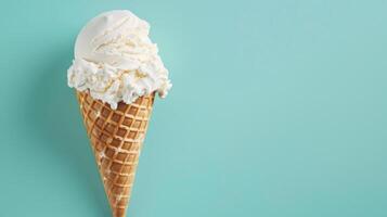 A Single Scoop Of Vanilla Ice Cream In A Waffle Cone On A Turquoise Background photo