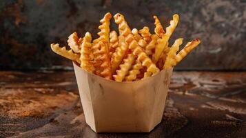 Crispy Waffle Fries in a Paper Container on a Wooden Table photo