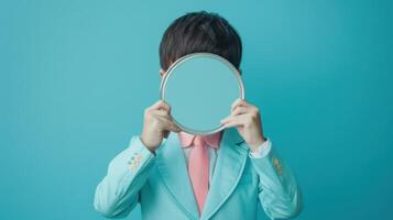 Man In Blue Suit Holds Round Mirror In Front Of Face photo