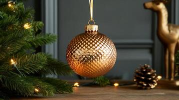 A Close-Up of a Golden Christmas Ornament Hanging Over a Wooden Surface photo