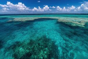 Clear turquoise waters over coral reefs under a blue sky. photo
