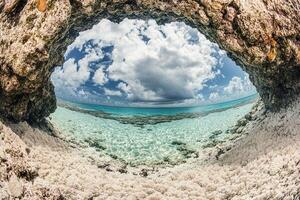 Coastal view through rocky arch, revealing clear waters. photo