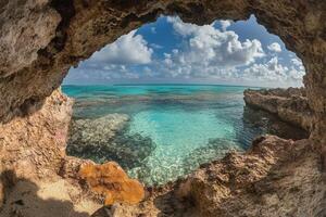 Scenic view of clear turquoise waters through a rocky arch. photo