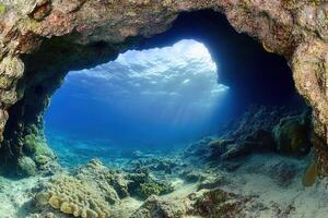 Underwater cave with coral and sunlight streaming through. photo