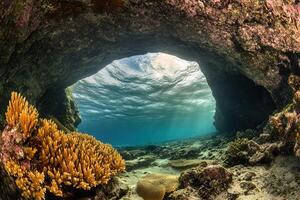 Underwater cave with coral and sunlight filtering through. photo
