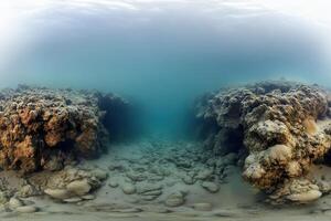Underwater scene with rocky formations and sandy floor. photo