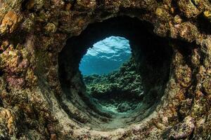 Underwater view through a rocky archway. photo