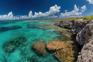 Vibrant coastal scene with clear turquoise waters and rocks. photo