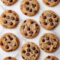 A collection of chocolate chip cookies on a white surface. photo