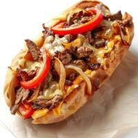 A delectable steak sandwich with onions and peppers, served in a bun. photo